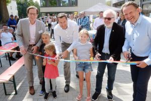 Fröhliches Band-Durchschneiden mit denen, die das beruflich machen: Die feierliche Eröffnung der Kita an der Hiltroper Landwehr.