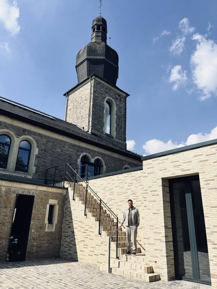 Die St. Nikolaus Kirche wurde erhalten. Der u-förmige Anbau fügt sich nahtlos an.