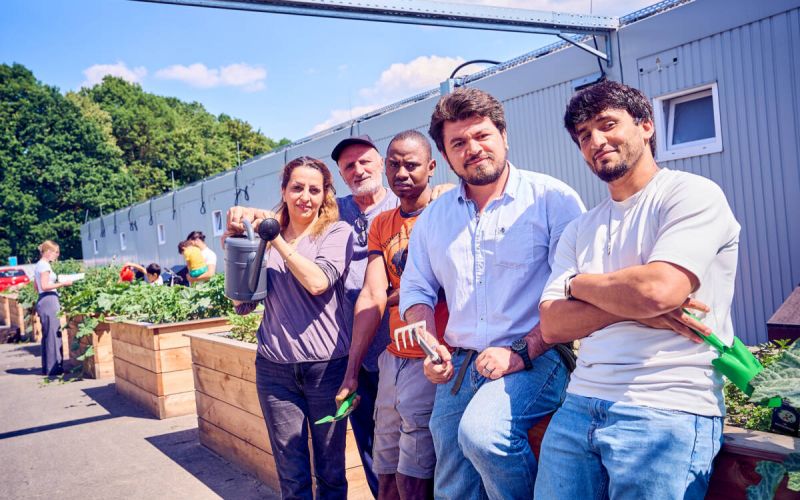 In der Gemeinschaftsunterkunft „Auf der Heide“ pflegen Bewohnerinnen und Bewohner gemeinsam mit Unterstützenden die angelegten Hochbeete des Urban-Gardening-Projekts. Das Projekt fördert Begegnung, Teilhabe und den gemeinschaftlichen Austausch im Alltag. Foto: Dennis Yenmez / Stadt Bochum